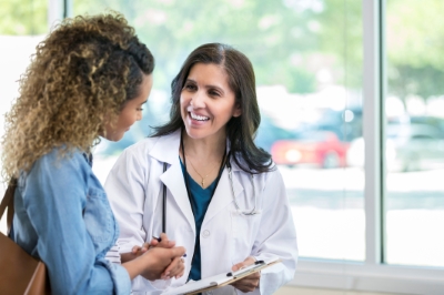 A doctor is warmly greeting her patient.